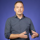 Jonathon Schofield in front of a blue background for a video shoot