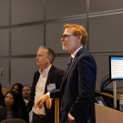 Two people stand in front of an audience