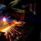 sparks fly as a student works on machinery