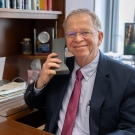 A man holds an early prototype of a cellphone in a well lit office