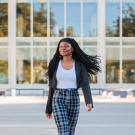 UC Davis Student Xaviera Azodoh walking outdoors with her hair swinging and one leg in front of the other
