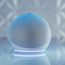 Amazon speaker device sits against a blue-white background and has a small ring of light around the bottom
