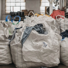 large piles of clothes in bags
