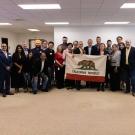 a large group of indoor air quality experts from uc davis college of engineering and the california department of public health holding up a flag for the state of california